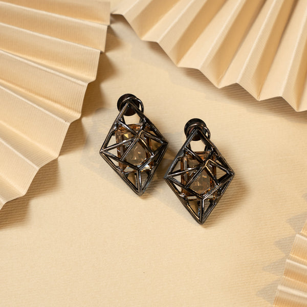 Pair of Allure Swarovski Earrings earrings with open diamond-shaped frames and dark metallic finish, on a pleated fabric