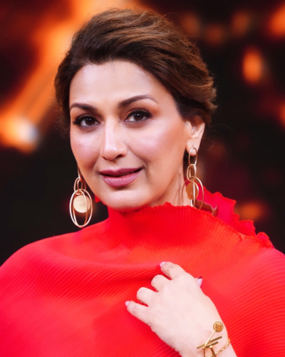 Front view of Sonali Bendre, wearing long, stylish earrings and bracelet